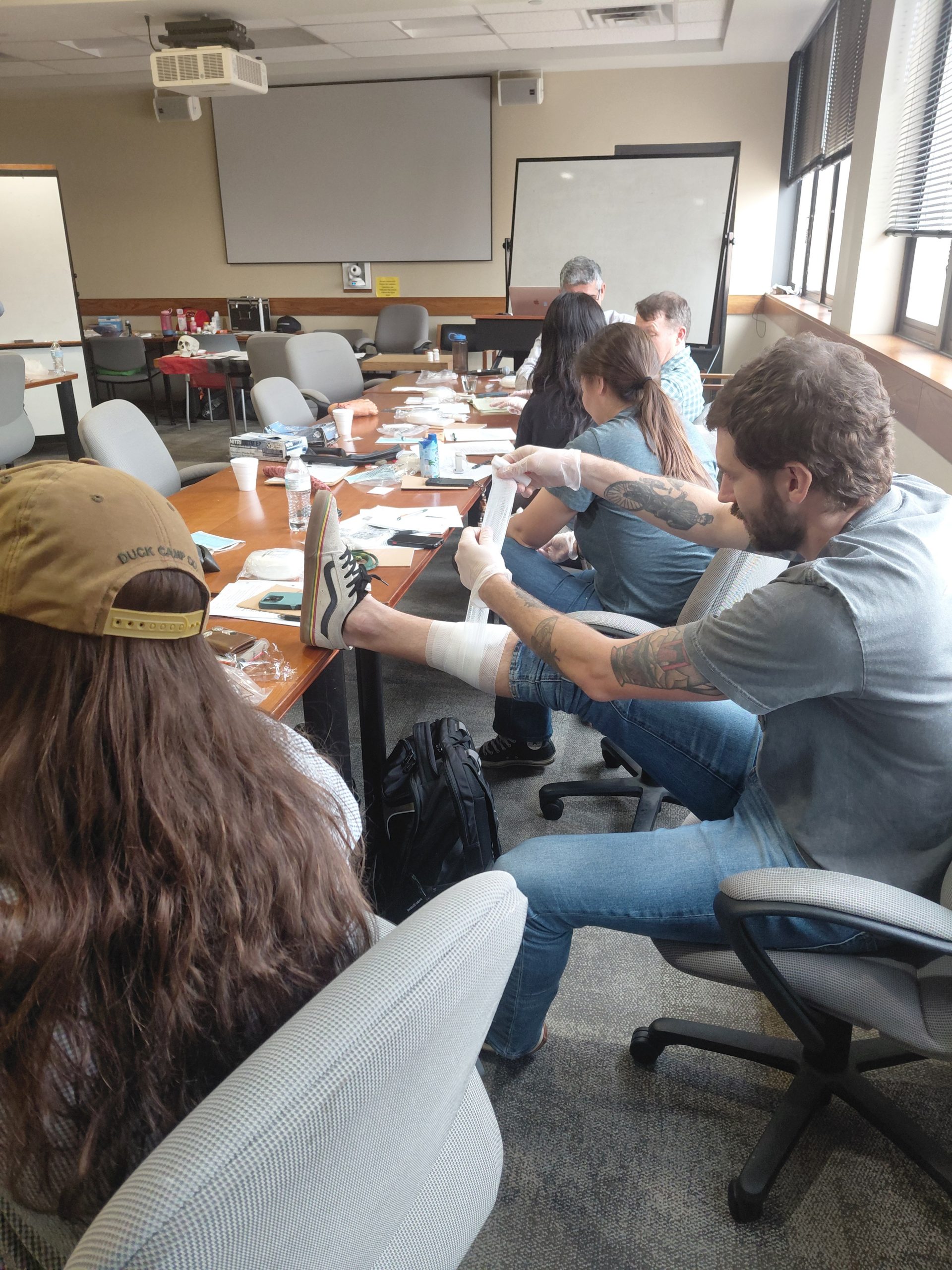Close-up of a student practicing bandage application on their leg<br />
during the hands-on portion of the Expedition School Wilderness First Aid course.